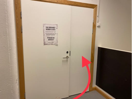 Valkoinen ovi hissin vasemmalla